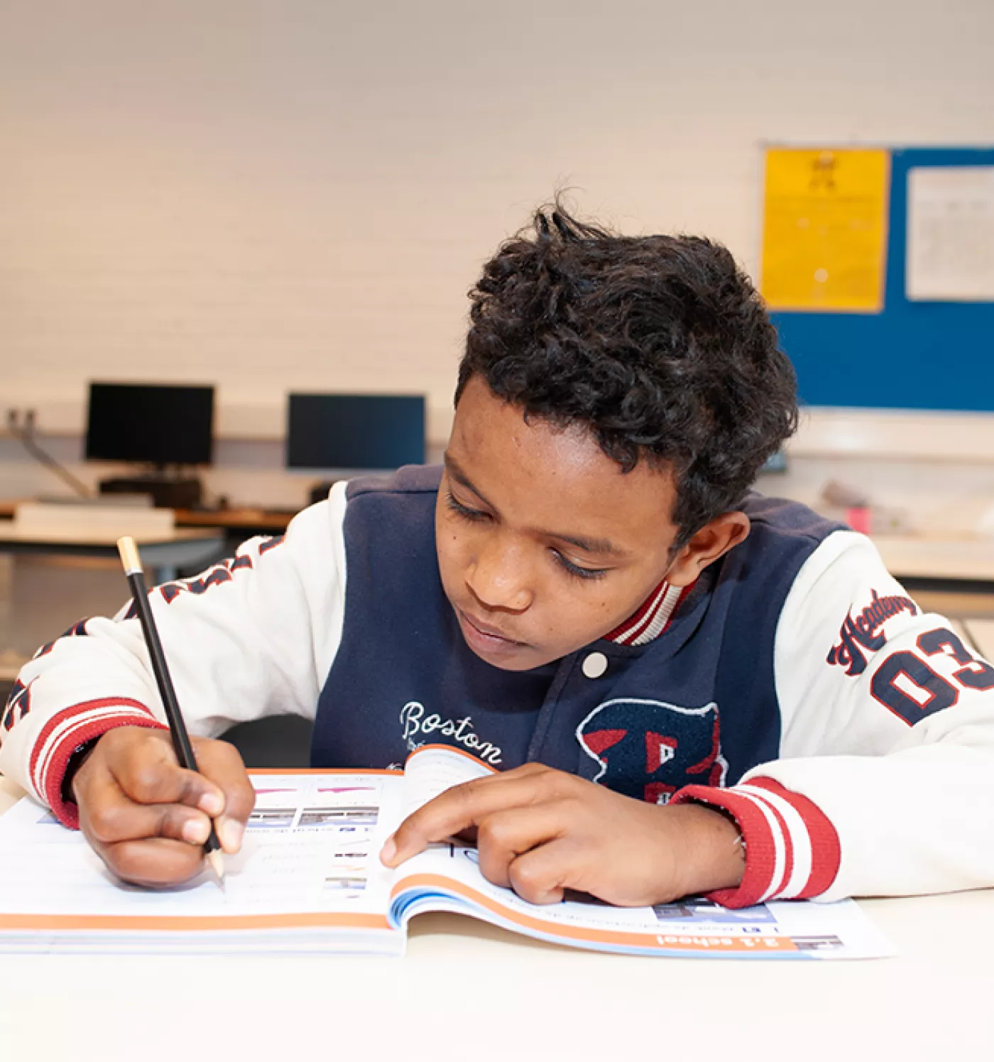 Leerling werkt met een werkboek.