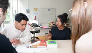 Leerlingen werken in een groepje in de klas.