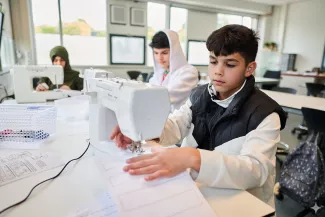 Leerlingen ISK werken met naaimachines.