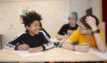 Leerlingen kijken elkaar lachend aan in het klaslokaal